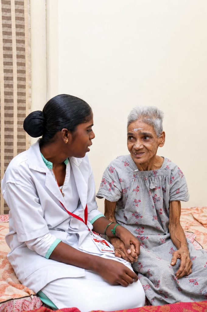 Caregiver holding hands with a smiling elderly resident